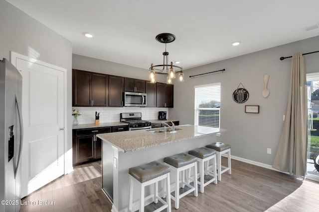 109 Kentucky Oaks Trl, Elizabethtown, KY 42701 - kitchen with tasteful backsplash, a sink, light wood-style floors, dark brown cabinets, and stainless steel appliances