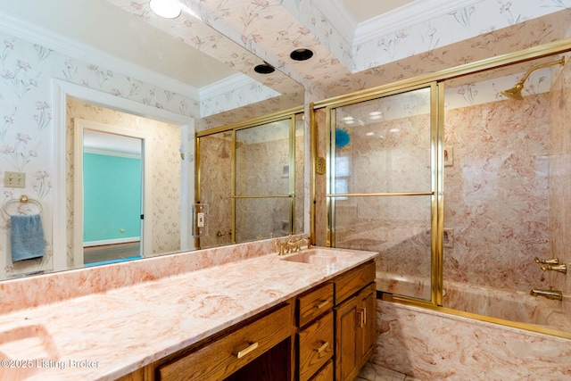 full bathroom featuring wallpapered walls, combined bath / shower with glass door, vanity, and crown molding