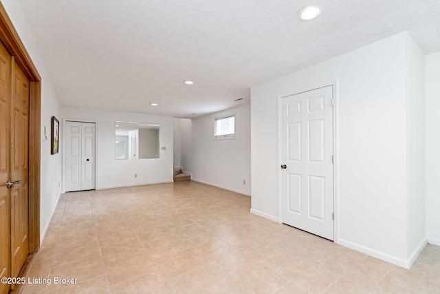 interior space featuring recessed lighting, baseboards, and light tile patterned flooring