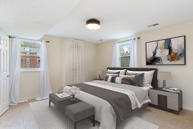 bedroom featuring light tile patterned flooring, baseboards, and visible vents