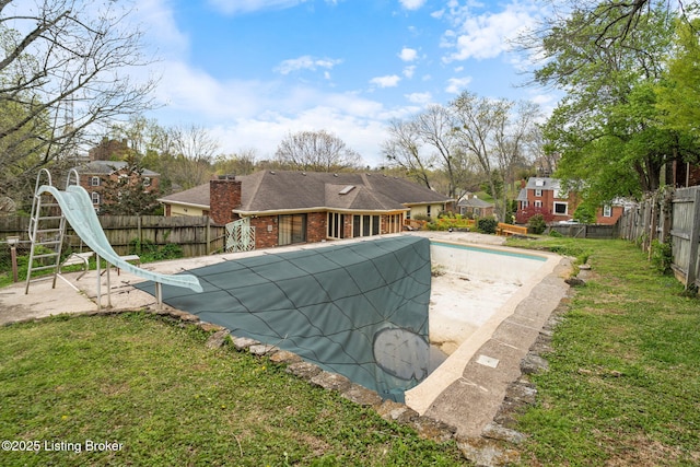 view of swimming pool featuring a fenced in pool, a water slide, a patio area, a fenced backyard, and a yard