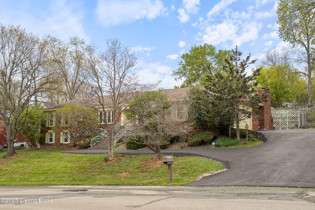 view of front of house with a front yard and aphalt driveway