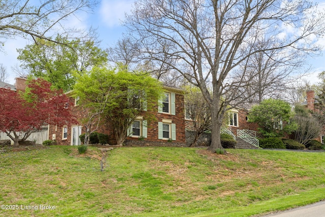 view of front of home featuring a front yard and brick siding