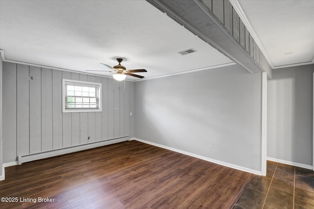 empty room with visible vents, a baseboard radiator, a ceiling fan, and baseboards