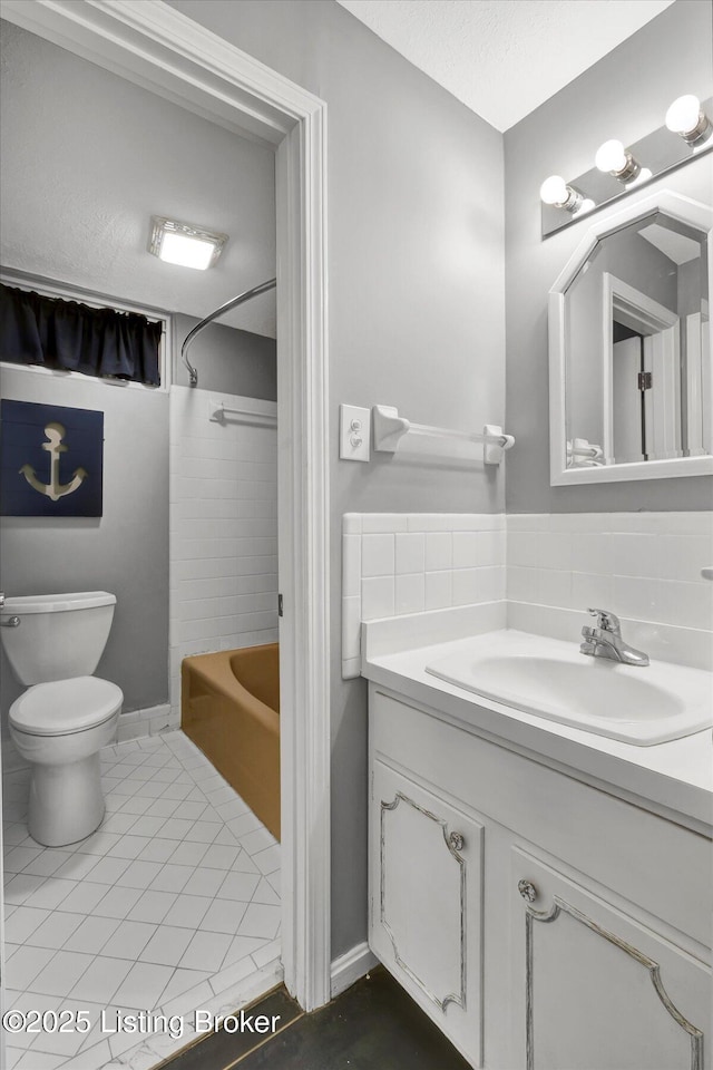 bathroom with toilet, shower / bath combination, vanity, and backsplash