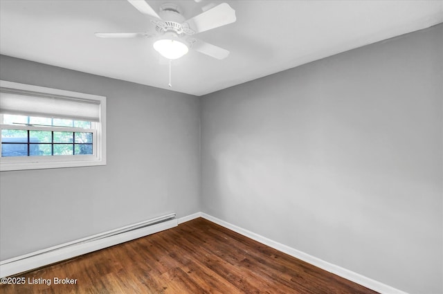 spare room with dark wood-style flooring, baseboards, ceiling fan, and baseboard heating