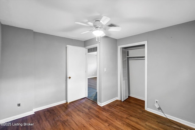 unfurnished bedroom with a closet, baseboards, visible vents, ceiling fan, and wood finished floors
