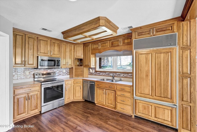 kitchen featuring stainless steel appliances, light countertops, a sink, and decorative backsplash