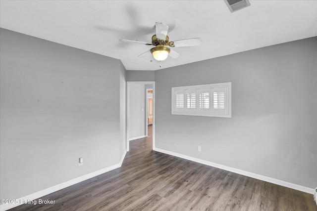 spare room featuring wood finished floors, ceiling fan, baseboards, and visible vents