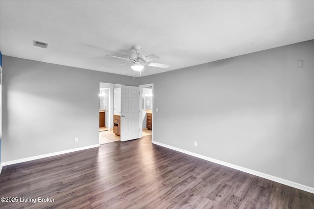 empty room featuring visible vents, ceiling fan, baseboards, and dark wood-style floors