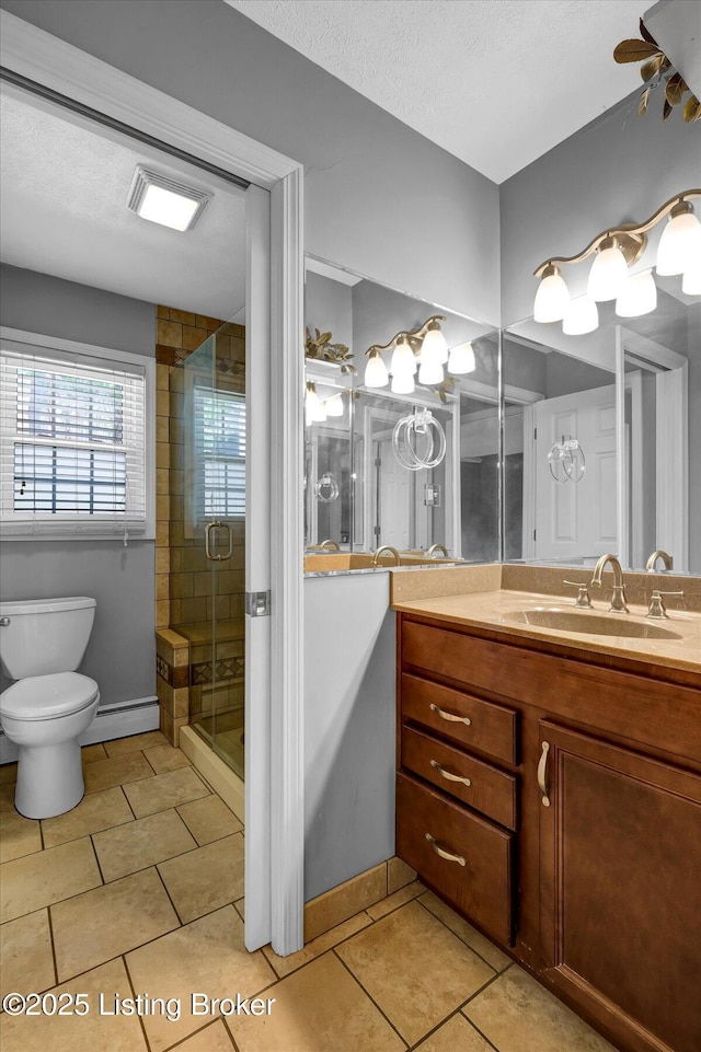 bathroom with toilet, a shower stall, vanity, tile patterned floors, and a baseboard heating unit