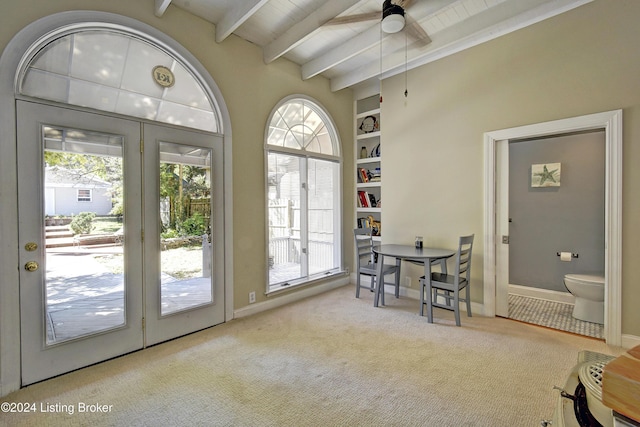 interior space featuring baseboards, built in shelves, ceiling fan, beam ceiling, and carpet floors