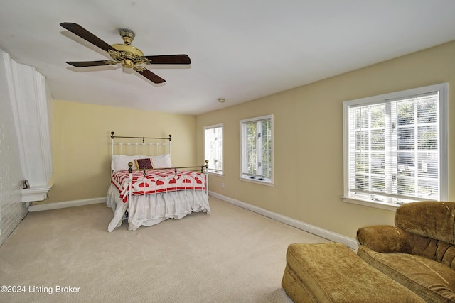bedroom with multiple windows, baseboards, a ceiling fan, and carpet floors