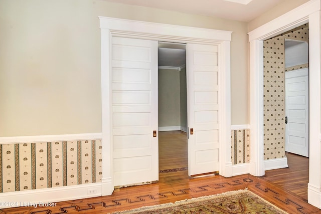 unfurnished bedroom with wood finished floors, baseboards, and a closet