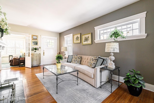 living area featuring plenty of natural light, visible vents, and wood finished floors