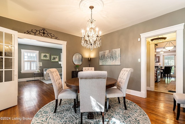 dining area with hardwood / wood-style floors, a chandelier, and a healthy amount of sunlight