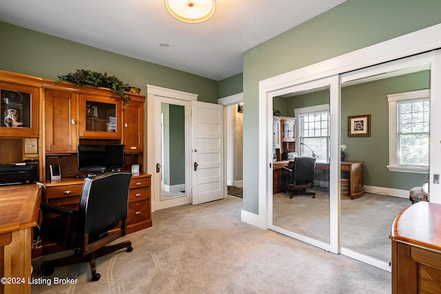 home office with light colored carpet and baseboards