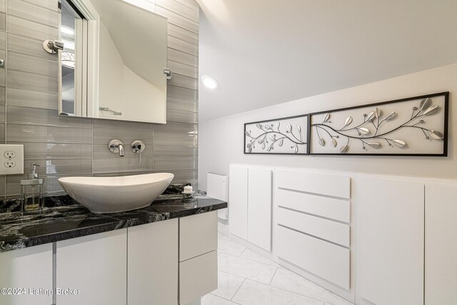 bathroom featuring vanity, backsplash, and tile patterned flooring