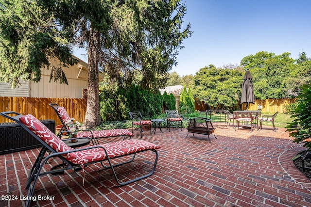 view of patio / terrace featuring an outdoor fire pit, outdoor dining space, and fence