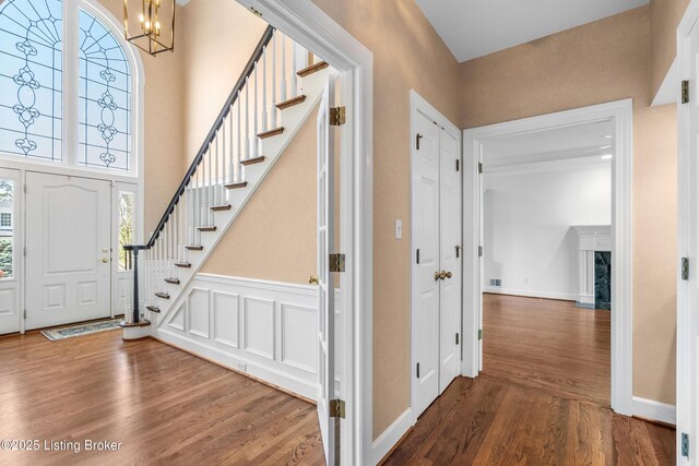 14801 Forest Oaks Dr, Louisville, KY 40245 - foyer with a fireplace, stairway, a notable chandelier, and wood finished floors