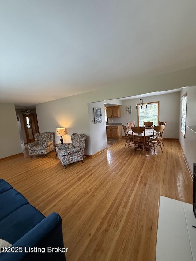 living area featuring light wood-style floors and baseboards