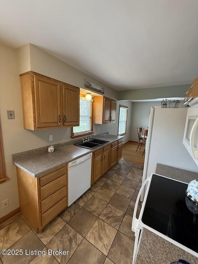 kitchen featuring white appliances and a sink