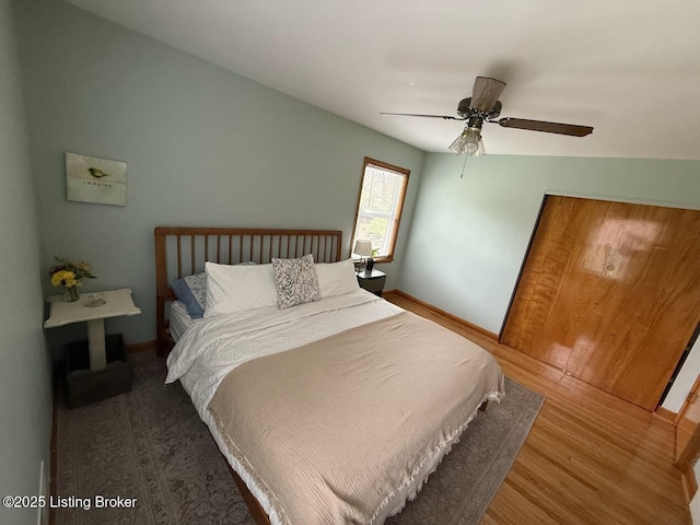 bedroom with baseboards, ceiling fan, and wood finished floors