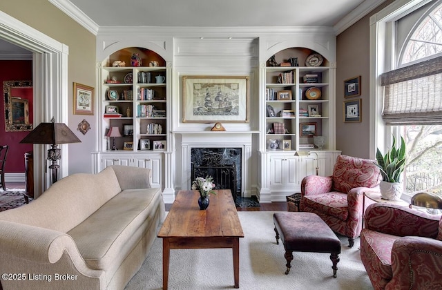 living room featuring crown molding, built in features, and a fireplace