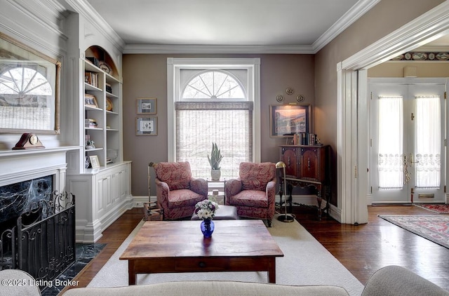 sitting room with dark wood-type flooring, baseboards, ornamental molding, and a premium fireplace