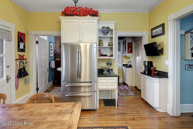 kitchen with white cabinets, light wood finished floors, freestanding refrigerator, and open shelves