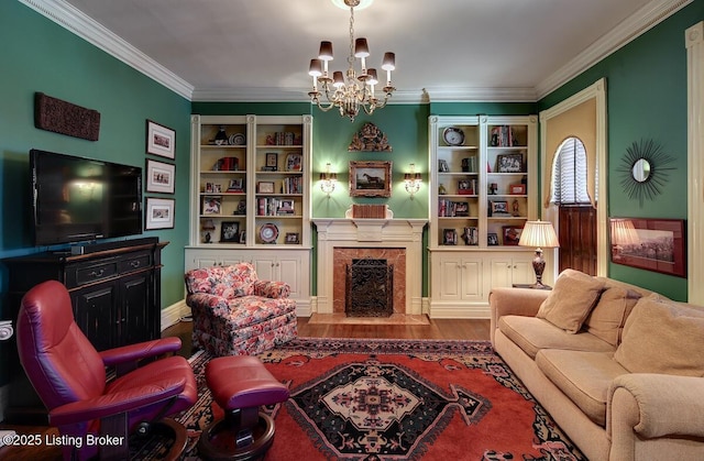 living room with built in features, a chandelier, a high end fireplace, crown molding, and wood finished floors