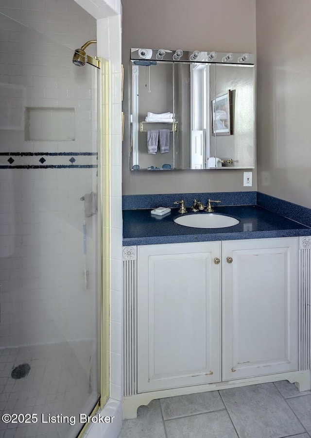 bathroom featuring tile patterned floors, vanity, and a stall shower