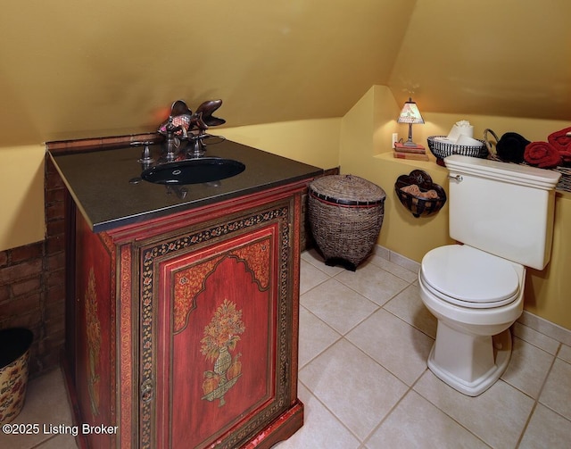 bathroom featuring toilet, tile patterned flooring, vaulted ceiling, and vanity