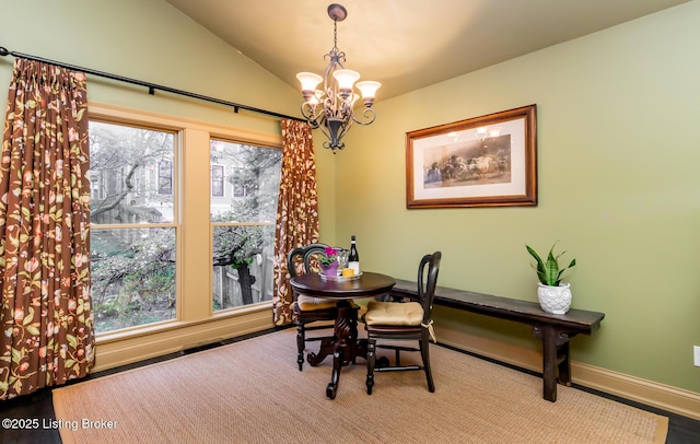 dining space with baseboards, a notable chandelier, vaulted ceiling, and plenty of natural light