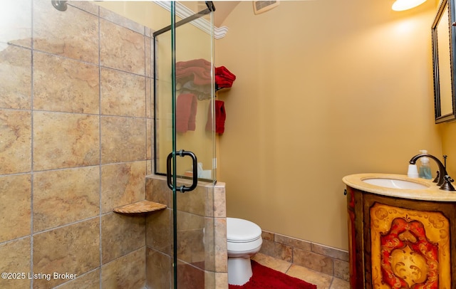 full bath featuring toilet, a shower stall, vanity, and baseboards