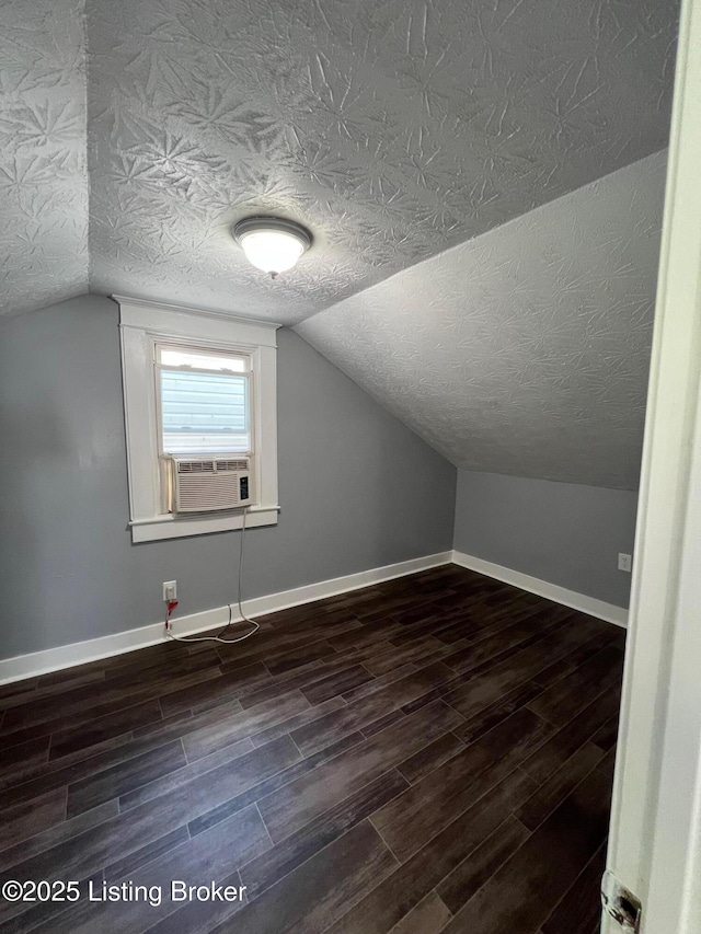 additional living space with dark wood-type flooring, cooling unit, and lofted ceiling