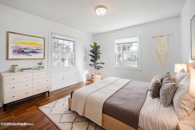 bedroom featuring dark wood-type flooring, baseboards, and multiple windows