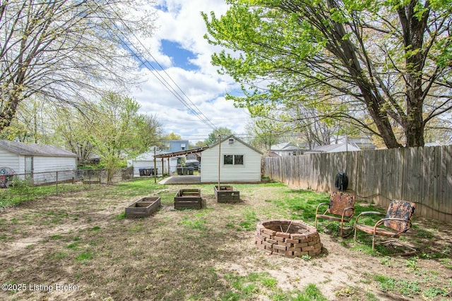 view of yard featuring an outdoor structure, an outdoor fire pit, and a fenced backyard