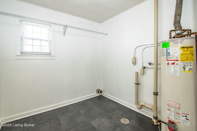 clothes washing area with laundry area, baseboards, and gas water heater