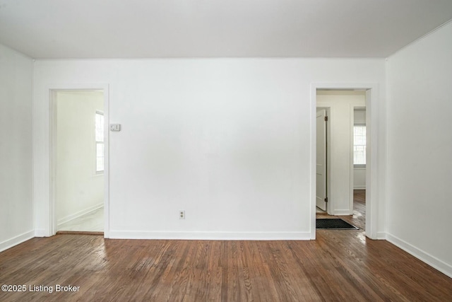 empty room with baseboards and dark wood-style floors
