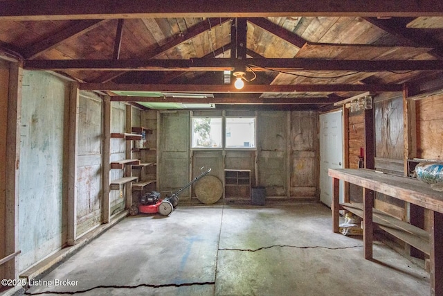 interior space featuring concrete flooring and vaulted ceiling