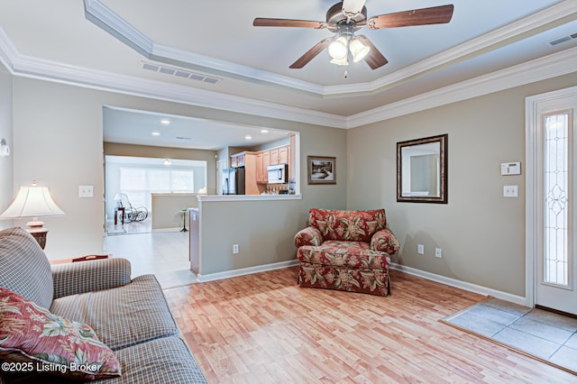 living room featuring visible vents, ornamental molding, and a healthy amount of sunlight
