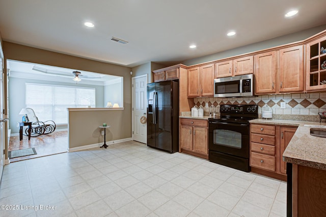 kitchen with tasteful backsplash, visible vents, baseboards, and black appliances