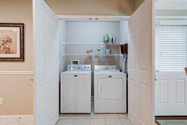 washroom with light tile patterned floors, separate washer and dryer, and laundry area