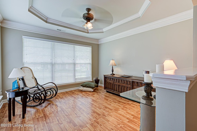 interior space featuring visible vents, ceiling fan, wood finished floors, and a raised ceiling