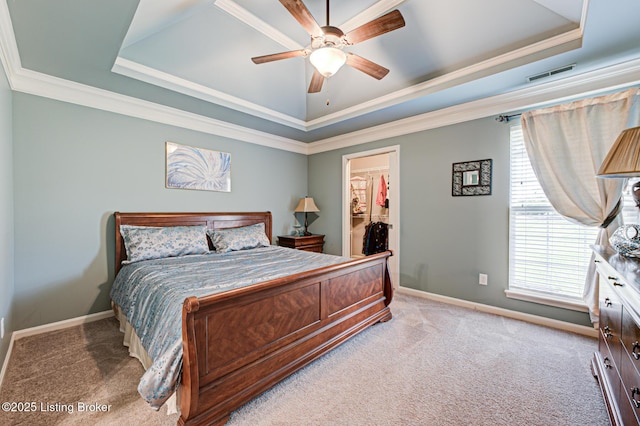 bedroom featuring a raised ceiling, a walk in closet, visible vents, and carpet floors