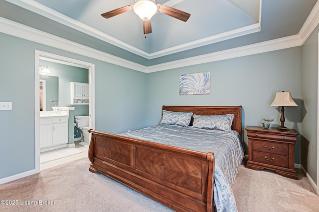 bedroom with a raised ceiling, carpet flooring, baseboards, and connected bathroom