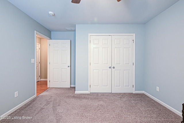 unfurnished bedroom with a closet, ceiling fan, baseboards, and carpet