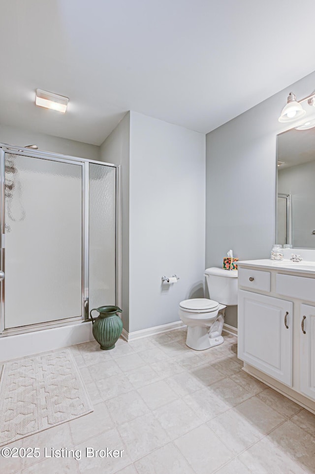 full bathroom featuring a shower stall, vanity, baseboards, and toilet