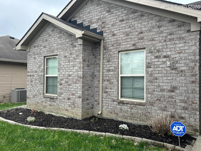 view of property exterior with brick siding and cooling unit
